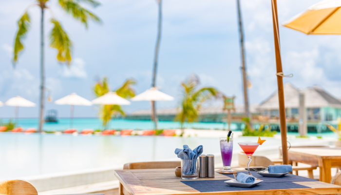 imagen mesa con cocteles variados en la playa 