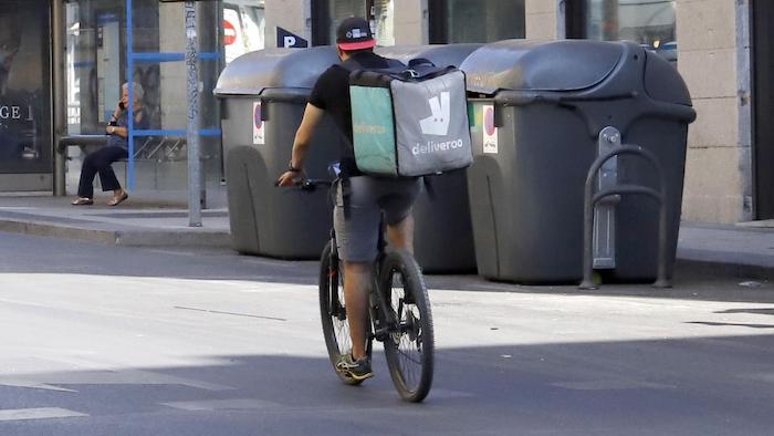un rider de deliveroo por la calle en la bici